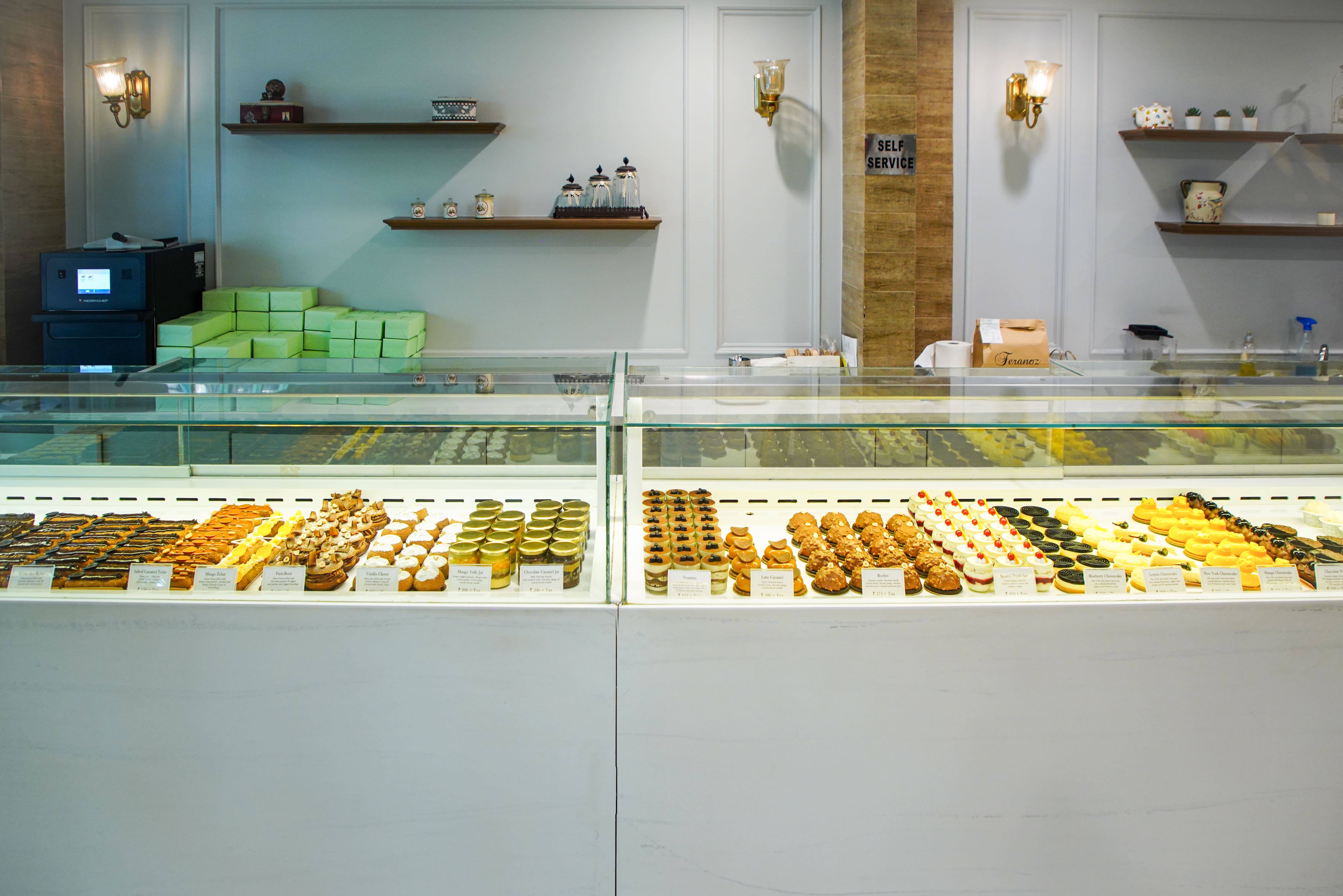 Pastry counter with éclairs, cheesecakes and dessert jars at Feranoz
